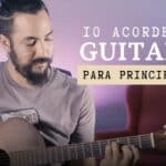 Persona practicando acordes de guitarra para principiantes en una guitarra acústica.